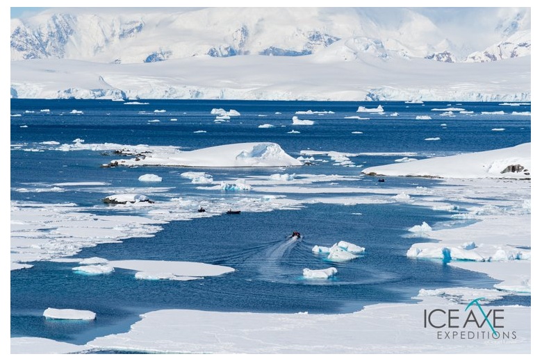 vue de la mer et la glace avec le canot qui avance à travers les icebergs